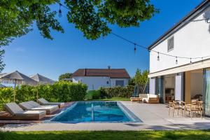 a backyard with a swimming pool and a house at House Serenity in Njivice