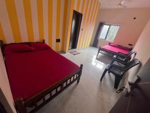 a bedroom with a bed and a table and chairs at Golden rays beach stay in Mangalore