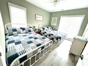 two beds in a bedroom with two windows at Birdies Rest in Little River +16 photos