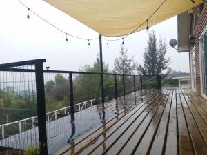 a deck with a canopy and a fence at Oceana Suites Limache con piscina in Limache