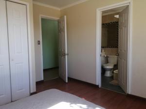 an empty bathroom with a toilet and a sink at Oceana Suites Limache con piscina in Limache