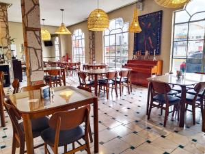 a restaurant with tables and chairs and a piano at Hotel Inn Galerias in Aguascalientes