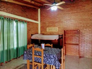 a room with a table and a bed with a ceiling fan at Cabañas Mi Atardecer in Nono