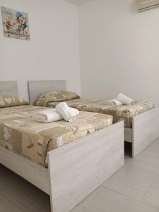 two beds in a room with white walls at Affittacamere La Casa Dei Nonni in Polizzi Generosa