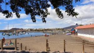 a group of people on a beach with boats in the water at Modern & Comfortable Apartment in Tenerife South in Guargacho