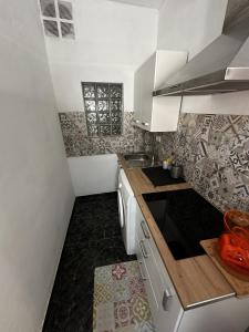 a small kitchen with white cabinets and a sink at Modern & Comfortable Apartment in Tenerife South in Guargacho