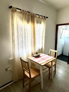 a dining room table with two chairs and a window at Modern & Comfortable Apartment in Tenerife South in Guargacho +1 photo