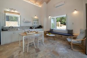 a kitchen with white cabinets and a table and chairs at Amaranthus house in Longós