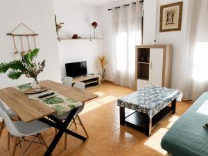 a living room with a table and chairs and a television at El Akito apartamento in Huéscar