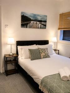 a bedroom with a bed with two lamps and a painting on the wall at Ushaw HillTop View-Suburban Free Parking Ideal for Work-Stays & Families in Ushaw Moor