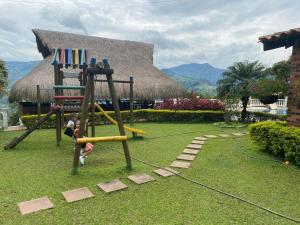 a child playing on a swing in a yard at Finca Los Pony Girardota Antioquia in Girardota
