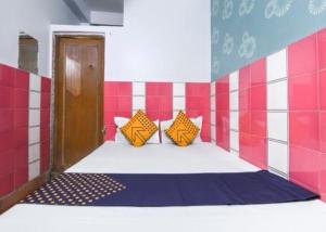 a room with a bed with orange pillows on it at Hotel O Snenanjali in Kolkata