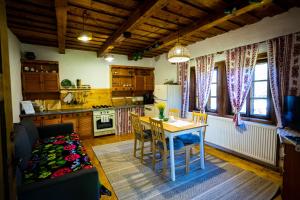 a kitchen and dining room with a table and chairs at DejaView Casa Veche in Rogojel