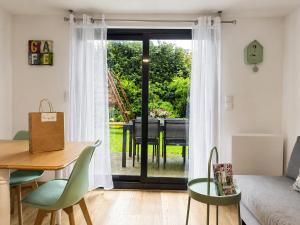 a living room with a table and a glass door at Au Charme De Bussy - Maison proche Disney avec terrasse et parking in Bussy-Saint-Georges