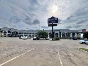 a building with a sign in a parking lot at Century Inn in Dallas