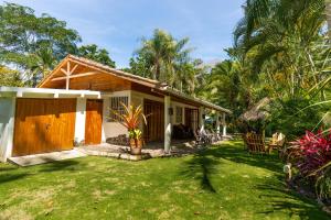 a house with a grass yard in front of it at Our Beachfront Bungalow in Puerto Viejo