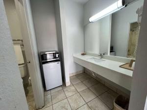 a bathroom with a sink and a washer and dryer at Century Inn in Dallas +5 photos