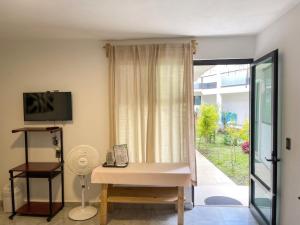 a living room with a table and a window at La Palma Coliving in San Lucas Xoloc