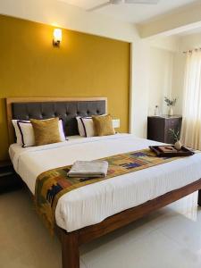 a large bed in a bedroom with yellow walls at Morjim Pride Hotel with Swimming Pool near Morjim Beach in Morjim +46 photos