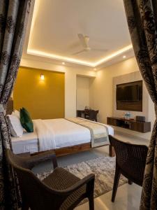 a hotel room with a bed and a television at Morjim Pride Hotel with Swimming Pool near Morjim Beach in Morjim