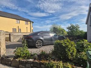 a car parked in the driveway of a house at Cottage on the hill in Carlow