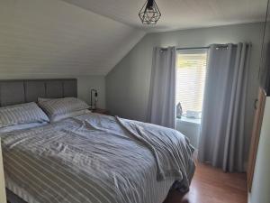 a bedroom with a bed and a window at Cottage on the hill in Carlow