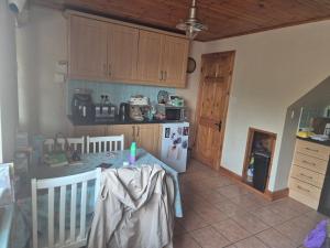 a kitchen with a crib and a table and a refrigerator at Cottage on the hill in Carlow