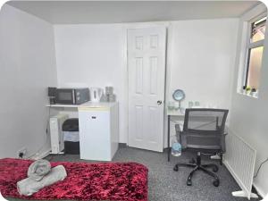 a bedroom with a bed and a desk and a chair at Double Room with attach Bathroom in London