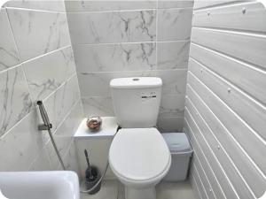 a white bathroom with a toilet and a sink at Double Room with attach Bathroom in London +3 photos