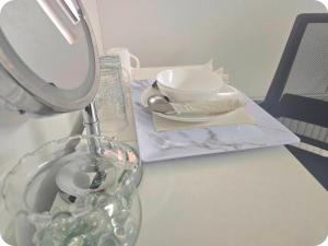 a table with a lamp and a plate and a mirror at Double Room with attach Bathroom in London