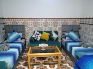 a living room with two blue couches and a coffee table at Dar Salima in Chefchaouen