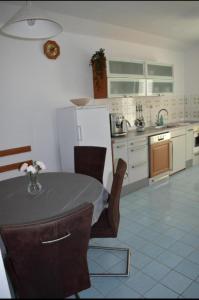 a kitchen with a table with chairs and a refrigerator at Elma in Kampor