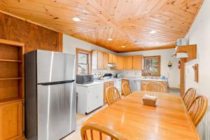 a kitchen with a wooden table and a refrigerator at River Road Treehouse Retreat in Warrensburg
