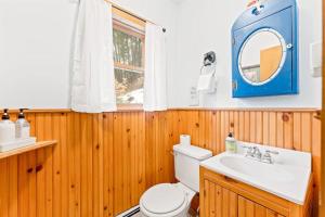 a bathroom with a toilet and a sink and a mirror at River Road Treehouse Retreat in Warrensburg +22 photos