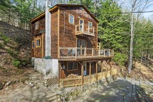 a large wooden house with a deck in the woods at River Road Treehouse Retreat in Warrensburg