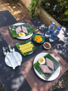 a picnic table with plates of food and eggs and cheese at Casa Cayena - Tangalle in Tangalle