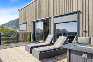 a patio with two lounge chairs on a deck at Moderne hus midt i Lofoten in Ballstad