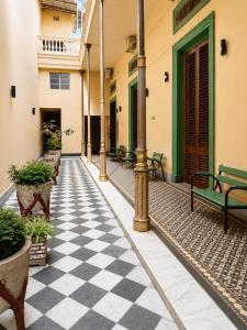 a courtyard with benches and a checkered floor at Hotel Histórico San Telmo in Buenos Aires