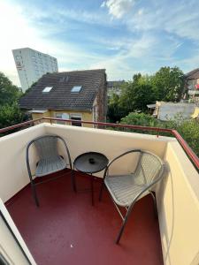two chairs and a table on a balcony at City Hub Room 22 - mit Balkon - Coffee for free - in Karlsruhe