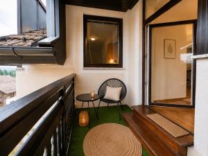 a small balcony with a chair and a table at Alpine Forest Apartments in Radovljica