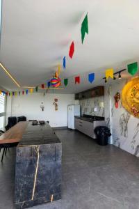 a kitchen with a table and flags on the ceiling at Apto Completo São João com Garagem e Piscina in Campina Grande