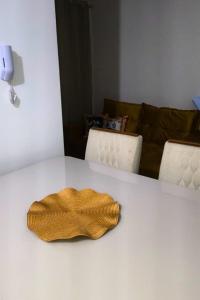 a yellow object sitting on a white table at Apto Completo São João com Garagem e Piscina in Campina Grande +2 photos