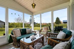 a screened in porch with a couch and chairs at C11348-Tarm-Laksestien-3 in Tarm