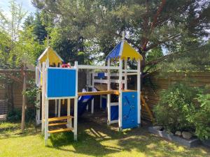 a playground with a slide and a play structure at Leśne Apartamenty in Hel