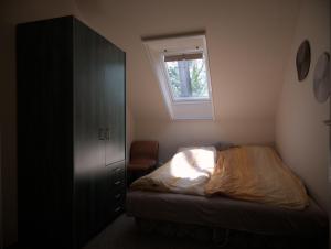 a bedroom with a bed and a cabinet and a window at Margaráta Vendégház in Soltvadkert +22 photos