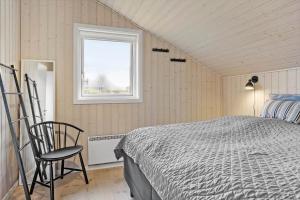 a bedroom with a bed and a window and a chair at 30178-Odder-Chr-Christensensvej-9 in Odder