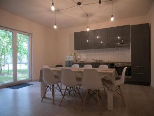 a kitchen and dining room with a table and chairs at Margaráta Vendégház in Soltvadkert