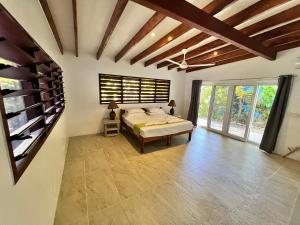 a bedroom with a bed in a room with windows at Turtle Bay Beach House in Saraotou +51 photos