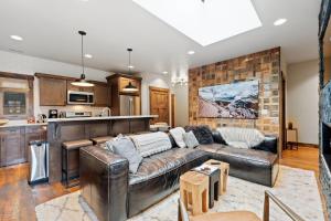 a living room with a leather couch and a kitchen at Central Loft 303 in Whitefish