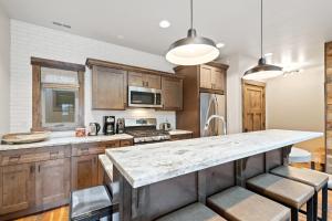a kitchen with wooden cabinets and a marble counter top at Central Loft 303 in Whitefish +23 photos